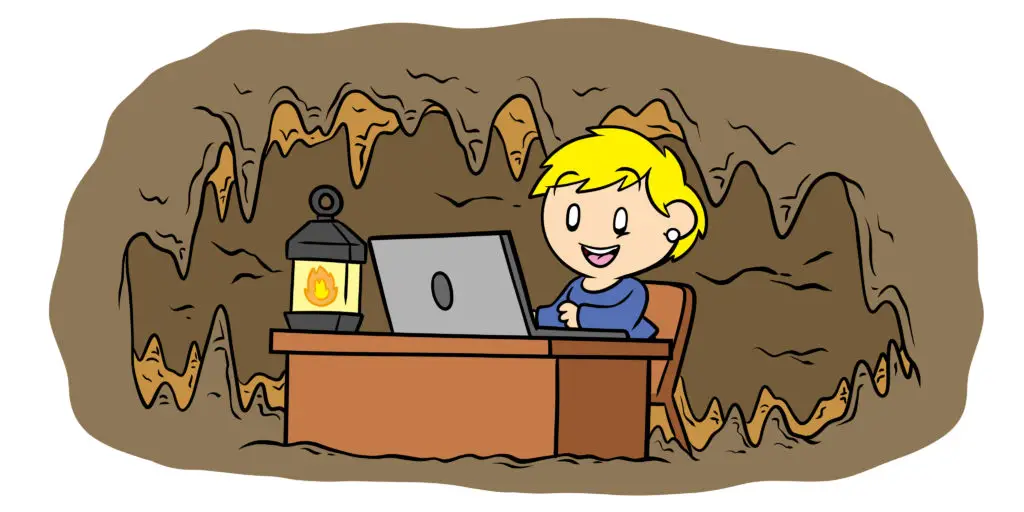 Why You Need A Dedicated Writing Space And How To Find It - A writer sets up their desk in a cave.